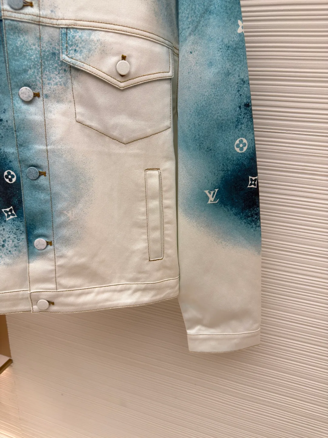 LOUIS VUITTON ink painting jacket ●Authentic product: Purchased and developed for 16900 ●Item number: 1680413-B90 ●Fabric: denim fabric ●Technology: made of semi-bleached fabric ●Version: loose version ●Weight: about 820 grams ●Size: 44-46-48-50 ●Description: The fabric is made of 7s*7s cotton twill gauze. Use semi-bleached fabric as the base, purchase Y version, scan the flower position and draw the print with PS, position the flower on the piece of cloth, add a red edge to the outer circle of the piece, accurately cut the piece with laser burning of the finished printed fabric, active digital direct-injection printing, white background water Ink painting gradient hollow letter effect, white gold aluminum alloy chain hanging from the genuine leather ears on the back collar, flat suede suede + hardware logo embossed leather plate on the back, and I-shaped buckles all made of gradient color cloth to match the color of the body part. The overall wiring is straight and delicate, the fabric is comfortable and soft, and the color is consistent without color difference. It can be matched with the same style to create a fashionable look and control various occasions. Customized accessories, complete with three standards, same style for men and women!